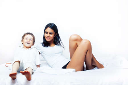 cute little boy in bed with mother in pajamas having fun happy smiling, lifestyle people conceptの写真素材