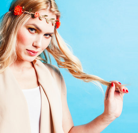 young blond woman dressed like ancient greek godess, beautiful girl hands manicured red nails on blue background copyspaceの写真素材