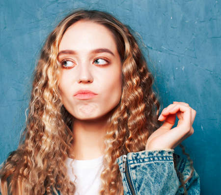 young pretty girl posing happy smiling on blue background, lifestyle people on summer vacation conceptの写真素材