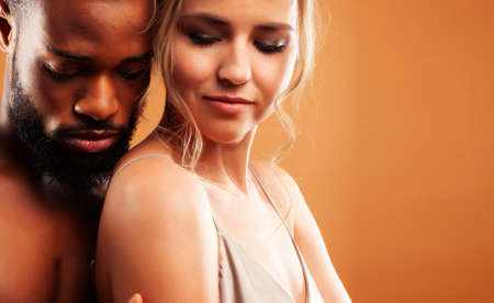 Young pretty couple diverse races together posing sensitive on brown background, lifestyle people conceptの写真素材