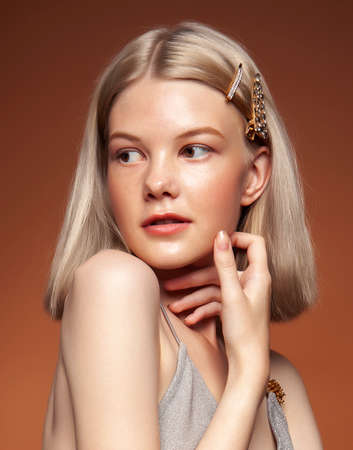 young pretty girl with blond hair posing cheerful on brown background, lifestyle people conceptの写真素材