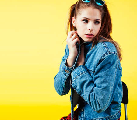 lifestyle people concept: pretty young school teenage girl having fun happy smiling on yellow backgroundの写真素材