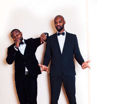 two african-american businessmen in black suits emotional posing, gesturing, smiling. wearing bow-tiesの写真素材