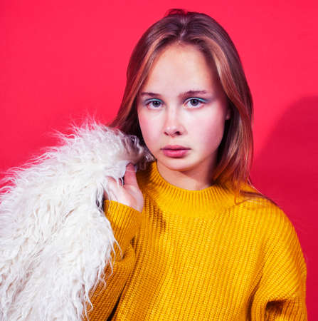 young pretty emitonal posing teenage girl on bright red background, happy smiling lifestyle people conceptの写真素材