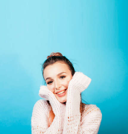 young pretty teenage modern hipster girl posing emotional happy on blue background, lifestyle people conceptの写真素材