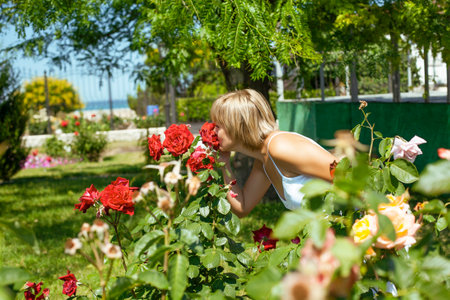 young pretty woman with cute daughter in rose garden at summer happy smiling, lifestyle people conceptの写真素材