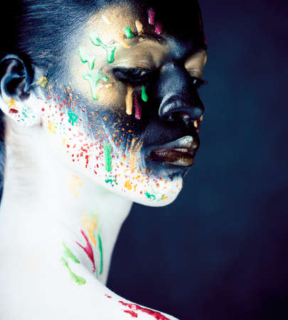 woman with creative makeup closeup like drops of colors, facepaint close up halloweenの写真素材