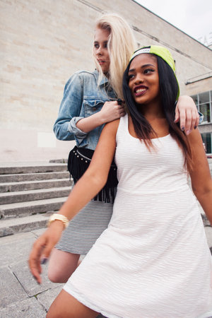 Two teenage diverse nations girls infront of university building smiling, having fun traveling europe, lifestyle people conceptの写真素材