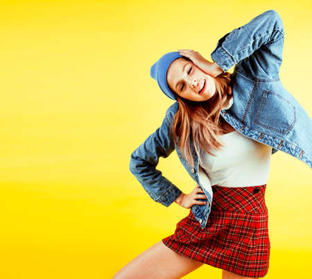 lifestyle people concept: pretty young school teenage girl having fun happy smiling on yellow backgroundの写真素材