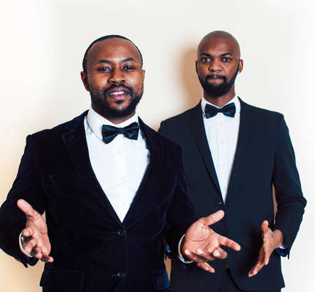 two african-american businessmen in black suits emotional posing, gesturing, smiling. wearing bow-tiesの写真素材