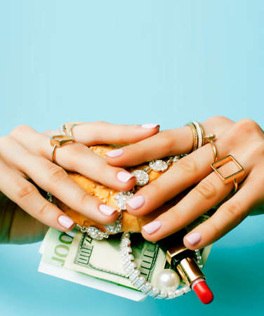 woman hands holding hamburger with money, jewelry, cosmeticの写真素材