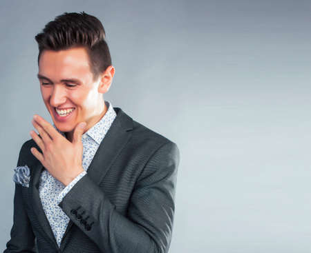 young pretty businessman posing emotional on grey background, lifestyle people concept close upの写真素材