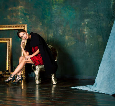 beauty rich brunette woman in luxury interior near empty frames, wearing fashion clothes, lifestyle people conceptの写真素材