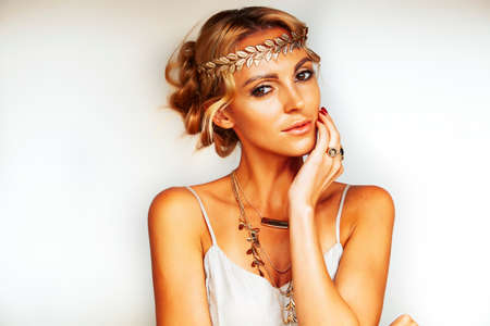young blond woman dressed like ancient greek godess, gold jewelry closeup isolated, beautiful girl hands manicured red nailsの写真素材