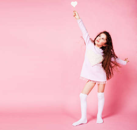 little cute girl with candy on pink background posing emotional, lifestyle people conceptの写真素材