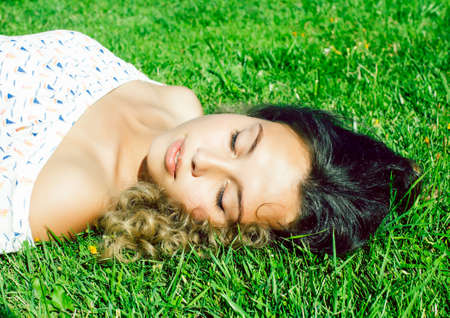 young cute summer girl on green grass outside relaxing smiling, lifestyle people conceptの写真素材