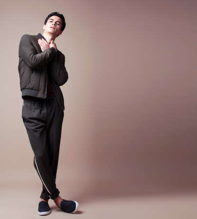 young pretty asian man posing in fashion style on light brown background, lifestyle people conceptの写真素材