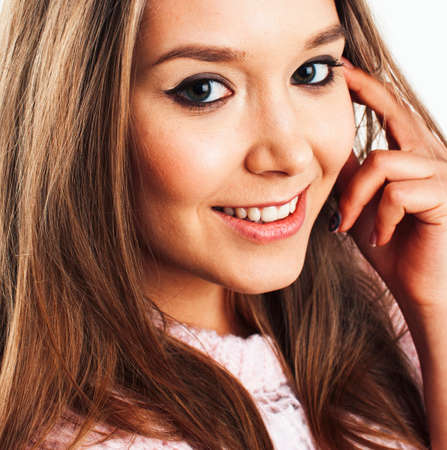 young pretty teenage hipster girl posing emotional happy smiling on white background, lifestyle people concept closeupの写真素材