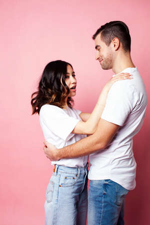 young cheerful caucasian couple together having fun on pink background, guy ang girl modern relationship, lifestyle people conceptの写真素材