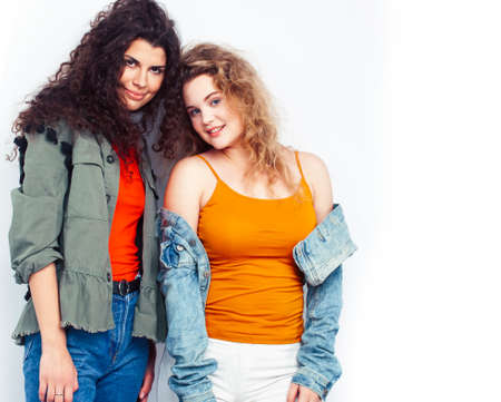 young pretty teenage girls friends with blond and brunette curly hairs posing cheerful isolated on...