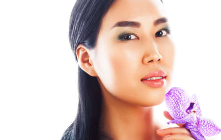 young pretty asian woman with flower purple orchid closeup isolated on white background spa smiling casualの写真素材