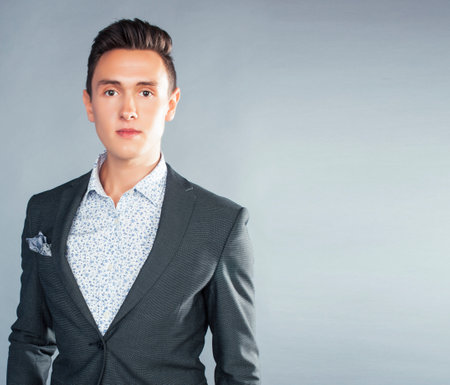 young pretty businessman posing emotional on gray background, lifestyle people concept closeupの写真素材