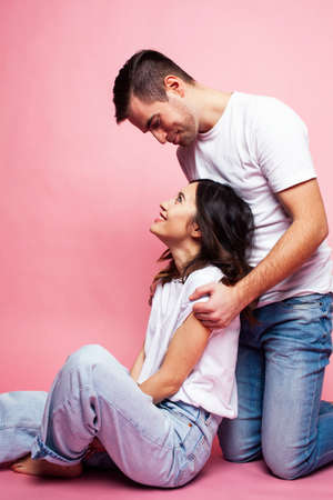 young cheerful caucasian couple together having fun on pink background, guy ang girl modern relationship, lifestyle people conceptの写真素材