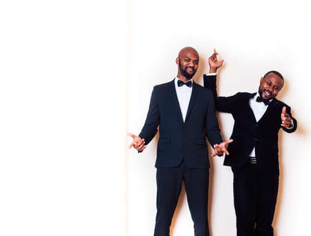 two african-american businessmen in black suits emotional posing, gesturing, smiling. wearing bow-tiesの写真素材