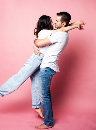 young cheerful caucasian couple together having fun on pink background, guy ang girl modern relationship, lifestyle people conceptの写真素材