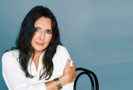 pretty brunette confident mature woman sitting on chair in studio, lifestyle people conceptの写真素材