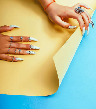 woman hands holding colorful paper copyspace wearing a lot of jewelry and long nailsの写真素材