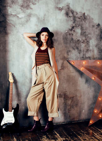 young pretty woman waiting alone in modern loft studio, fashion clothers wearing hat, lifestyle and people home conceptの写真素材