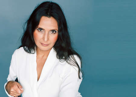 pretty brunette confident mature woman sitting on chair in studio, lifestyle people conceptの写真素材