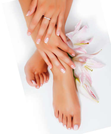 manicure pedicure with flower lily closeup isolated on white perfect shape hands spa salonの写真素材
