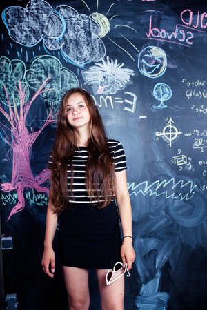 back to school after summer vacations, cute teen girl in classroomの写真素材