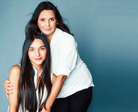 cute pretty teen daughter with mature mother hugging, fashion style brunette, lifestyle people conceptの写真素材