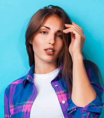 young pretty girl posing happy smiling on blue background, lifestyle people on summer vacation conceptの写真素材