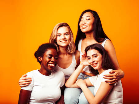 diverse multi nation girls group, teenage friends company cheerful having fun, happy smiling, cute posing on yellow background, lifestyle people concept, african-american, asian and caucasianの写真素材