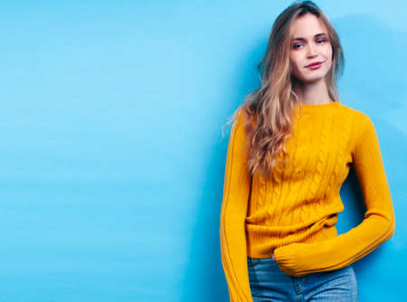young pretty girl posing happy smiling on blue background, lifestyle people on summer vacation conceptの写真素材
