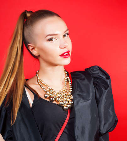 young pretty woman young lady posing on red background, lifestyle people conceptの写真素材
