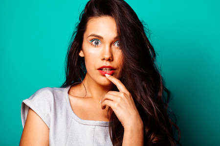 young pretty adorable brunette woman with curly hair closeup like doll makeup on blue background,...