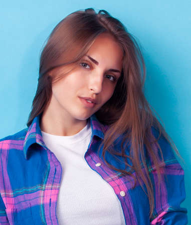 young pretty girl posing happy smiling on blue background, lifestyle people on summer vacation conceptの写真素材