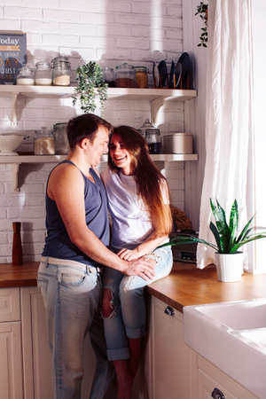 young caucasian couple together having fun on kitchen, woman pregnant, lifestyle people conceptの写真素材