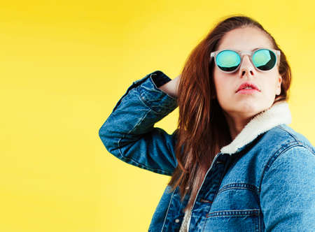 lifestyle people concept: pretty young school teenage girl having fun happy smiling on yellow backgroundの写真素材