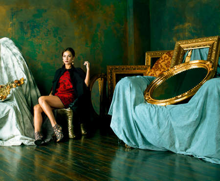 beauty rich brunette woman in luxury interior near empty frames, wearing fashion clothes, lifestyle people conceptの写真素材