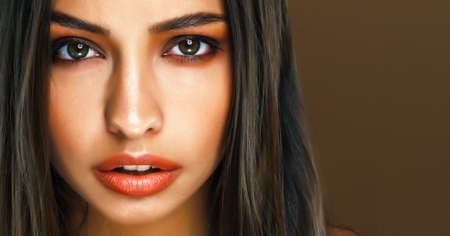cute happy young indian woman in studio closeup smiling on brown background, fashion beauty lifestyle people conceptの写真素材