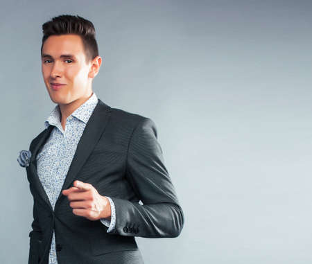 young pretty businessman posing emotional on gray background, lifestyle people concept closeupの写真素材