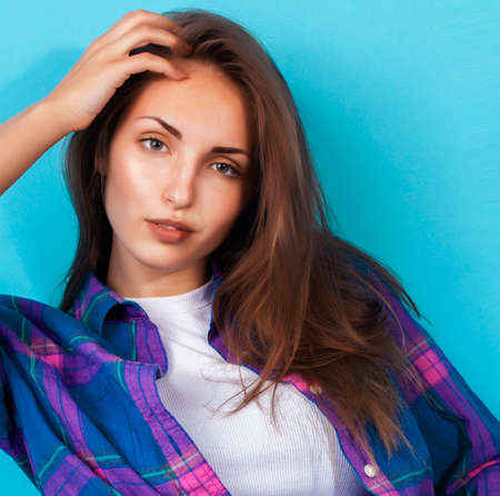 young pretty girl posing happy smiling on blue background, lifestyle people on summer vacation conceptの写真素材