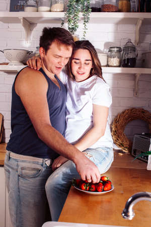 young caucasian couple together having fun on kitchen, woman pregnant, lifestyle people conceptの写真素材