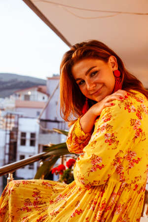young red hair woman looking on sunset alone on balcony, lifestyle people conceptの写真素材